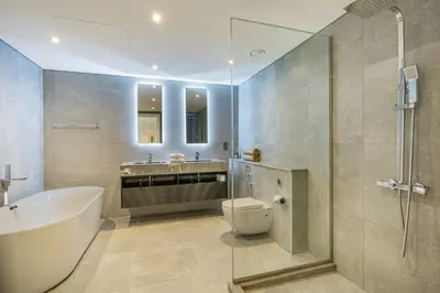 a bathroom with a tub and a toilet and a sink at Palm Home next to Nakheel Mall with Private Beach in Dubai