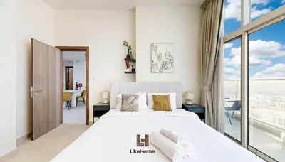 a bedroom with a large bed and a large window at Family-Friendly 2BR in Azizi Plaza with Pool & Gym in Dubai