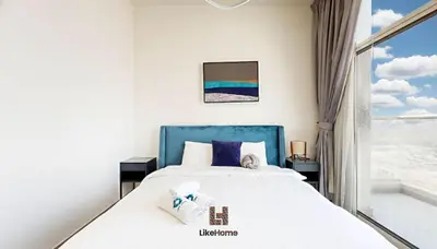 a bedroom with a bed and a large window at Family-Friendly 2BR in Azizi Plaza with Pool & Gym in Dubai