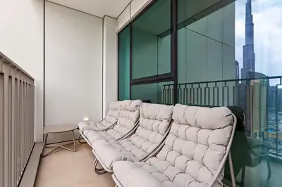 a living room with a couch on a balcony at Luxury 2BR Downtown Steps from Burj Khalifa in Dubai