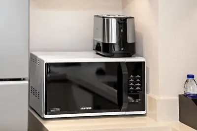 a microwave with a coffee maker on top of it at Luxury 2BR Downtown Steps from Burj Khalifa in Dubai