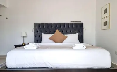 a bedroom with a large bed with a black headboard at Modern Stay in Azizi Samia1BR Al Furjan in Dubai
