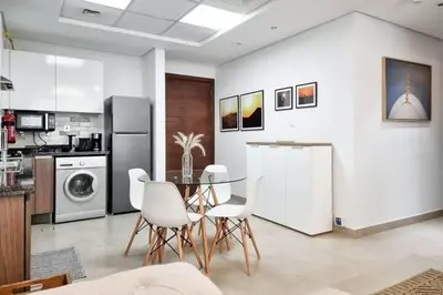 a kitchen and dining room with a table and chairs at Modern Stay in Azizi Samia1BR Al Furjan in Dubai