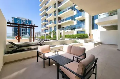a balcony with a table and chairs and a building at Modern Stay in Azizi Samia1BR Al Furjan in Dubai
