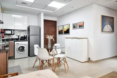 a kitchen and dining room with a table and chairs at Modern Stay in Azizi Samia1BR Al Furjan in Dubai