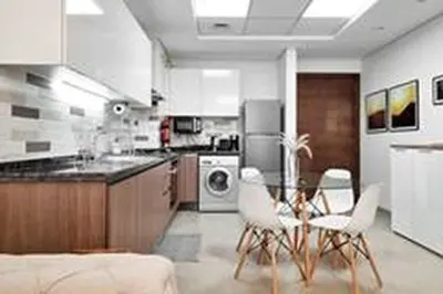 a kitchen with a table and chairs in a kitchen at Modern Stay in Azizi Samia1BR Al Furjan in Dubai