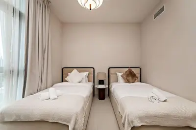 two beds in a room with white walls and a window at Luxury 2BR Burj Crown Stay Downtown in Dubai