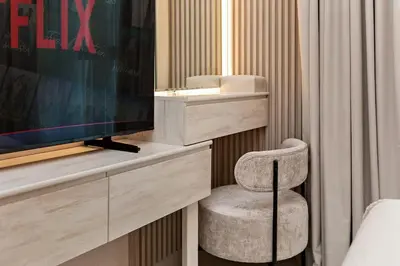 a room with a chair and a television in a bedroom at Luxury 2BR Burj Crown Stay Downtown in Dubai