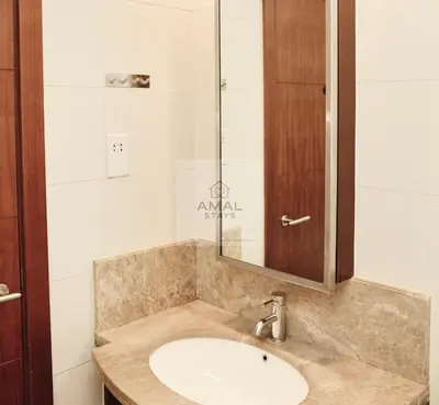 a bathroom with a sink and a glass shower at Modern 1BR theme and Burj Khalifa View Downtown in Dubai