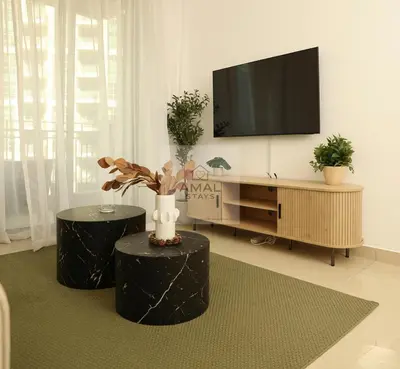 a living room with two black stools and a flat screen tv at Modern 1BR theme and Burj Khalifa View Downtown in Dubai