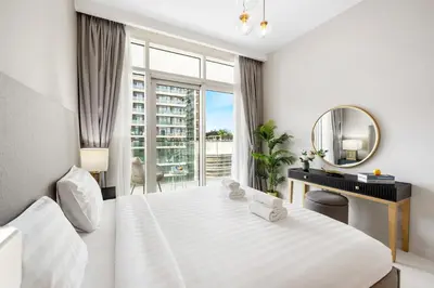 a white bedroom with a large bed and a mirror at BLVD-Beachfront Luxe Stay with Private Beach Access in Dubai