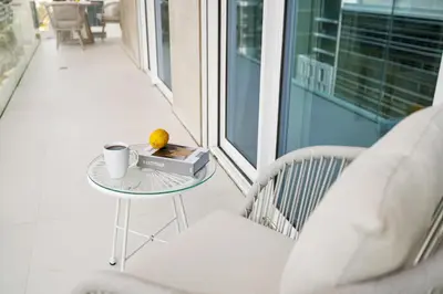 a table with a book and a cup of coffee on a balcony at BLVD-Beachfront Luxe Stay with Private Beach Access in Dubai