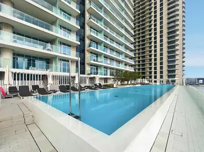 an empty swimming pool in front of a building at BLVD-Beachfront Luxe Stay with Private Beach Access in Dubai