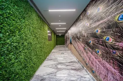a hallway with a wall covered in green plants at HiGuests - Charming Studio with Lake Views in Business Bay in Dubai
