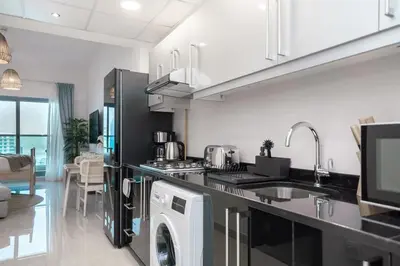 a kitchen with a washer and dryer in it at HiGuests - Charming Studio with Lake Views in Business Bay in Dubai