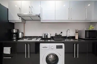 a kitchen with a washing machine in a kitchen at HiGuests - Charming Studio with Lake Views in Business Bay in Dubai