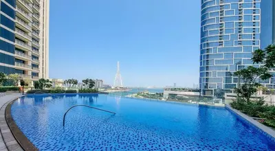 a large swimming pool in a city with tall buildings at Luxury Bluewater Escape 1BR Canal view 5242T in Dubai
