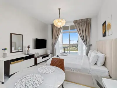 a bedroom with a bed and a table and a tv at Luxurious Haven Studio In Jewelz Arjan 03 in Dubai