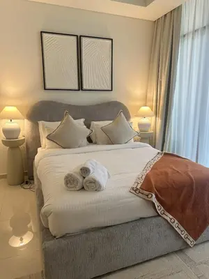 a bedroom with a large bed with towels on it at Luxury Studio With Pool View Near Burj Khalifa in Dubai