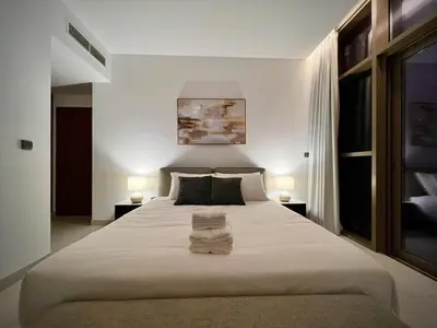 a bedroom with a large bed with towels on it at Modern 2-Bedrooms Apartment with Stunning Marina Views in Dubai