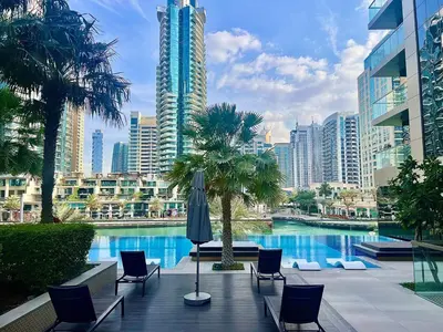 a pool in a city with chairs and a building at Modern 2-Bedrooms Apartment with Stunning Marina Views in Dubai
