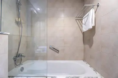 a bathroom with a shower and a bath tub at Modern Luxury Stylish 2BR Near Downtown Aykon C in Dubai