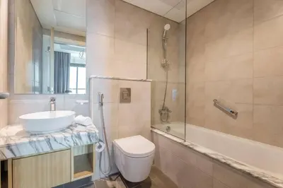 a bathroom with a toilet and a sink and a shower at Modern Luxury Stylish 2BR Near Downtown Aykon C in Dubai