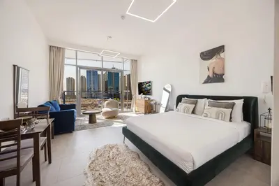 a bedroom with a large bed and a living room at Daniels Studio at V2 Residence, Sports City in Dubai
