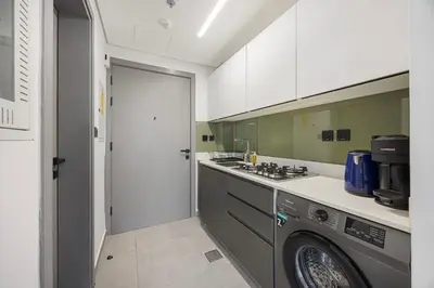 a kitchen with a washer and a washing machine at Daniels Studio at V2 Residence, Sports City in Dubai