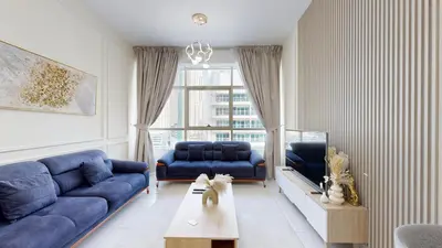 a living room with a blue couch and a table at Marina View Tower 2BR Stunning Canal Views in Dubai