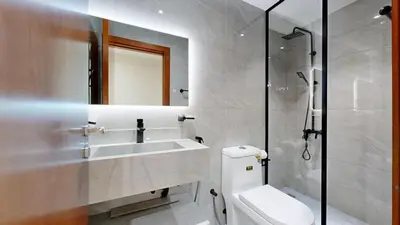 a bathroom with a sink and a toilet and a shower at Marina View Tower 2BR Stunning Canal Views in Dubai