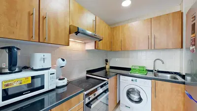 a kitchen with a washing machine and a microwave at Marina View Tower 2BR Stunning Canal Views in Dubai