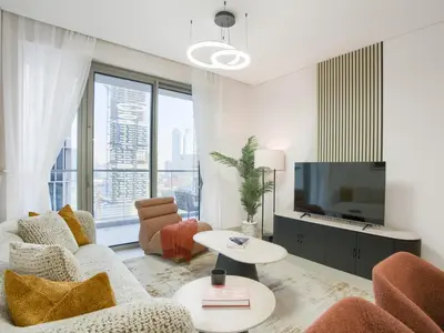 a living room with a couch and a tv at Vida Residences 2BR-Direct Dubai Mall Access in Dubai