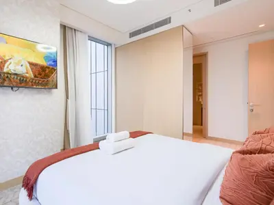 a bedroom with a white bed and a large window at Vida Residences 2BR-Direct Dubai Mall Access in Dubai