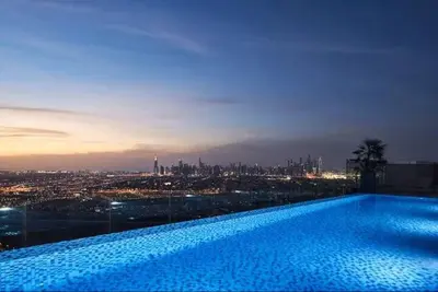 a large swimming pool with a view of a city at Vogue JVT Novotel near Springs Souk Mall, One Bedroom apartment with Balcony and Vibrant Community View, Access to all Amenities in Dubai