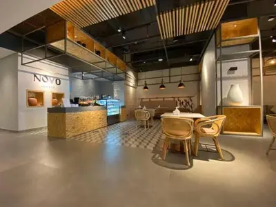 a room with a table and chairs and a kitchen at Vogue JVT Novotel near Springs Souk Mall, One Bedroom apartment with Balcony and Vibrant Community View, Access to all Amenities in Dubai