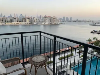 a balcony with a view of a river and buildings at La Mer Iconic View 1 bedroom in Dubai