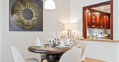a dining room with a table with chairs and a mirror at Downtown 2BHK Burj View & Private Garden in Dubai