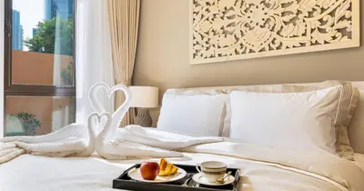 a bed with a tray of food on it at Downtown 2BHK Burj View & Private Garden in Dubai