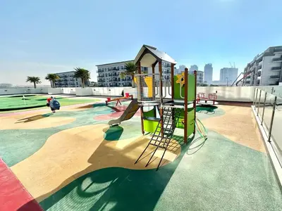 a playground with a slide on a roof at Inviting Studio Overlooking the Pool, Just a Short Drive from Dubai Autodrome, Samana Golf Avenue, Dubai Studio City by Deluxe Holiday Homes in Dubai