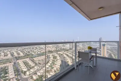 a balcony with a desk and a view of a city at Vogue JVT Novotel near Springs Souk Mall, One Bedroom apartment with Balcony and Vibrant Community View, Access to all Amenities in Dubai