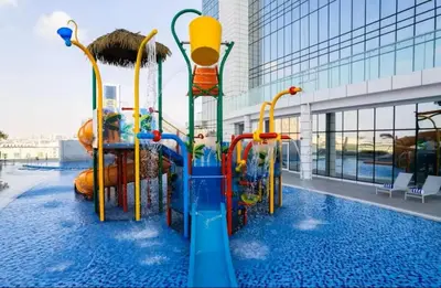 a water slide in a pool in a building at Vogue JVT Novotel near Springs Souk Mall, One Bedroom apartment with Balcony and Vibrant Community View, Access to all Amenities in Dubai