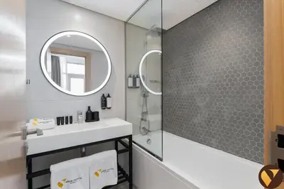a bathroom with a sink and a mirror at Vogue JVT Novotel near Springs Souk Mall, One Bedroom apartment with Balcony and Vibrant Community View, Access to all Amenities in Dubai