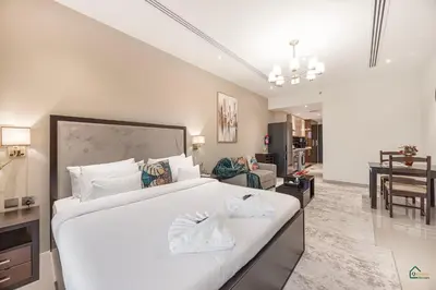 a bedroom with a large white bed and a living room at Luxury Studio Retreat! Heart of Downtown Dubai! in Sabkhah