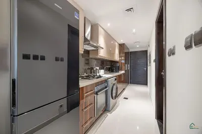 a kitchen with a stove and a refrigerator at Luxury Studio Retreat! Heart of Downtown Dubai! in Sabkhah