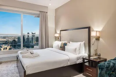 a bedroom with a large bed and a large window at Luxury Studio Retreat! Heart of Downtown Dubai! in Sabkhah