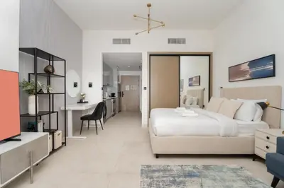 a bedroom with a bed and a desk and a kitchen at GuestReady - Studio l Partial Burj Khalifa View in Dubai
