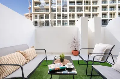 a patio with a couch and a table on a roof at Airstay - Stylish Studio - Spacious Balcony - Monthly Offer Available! in Dubai
