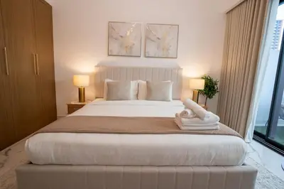 a bedroom with a large white bed with two lamps at Airstay - Stylish Studio - Spacious Balcony - Monthly Offer Available! in Dubai