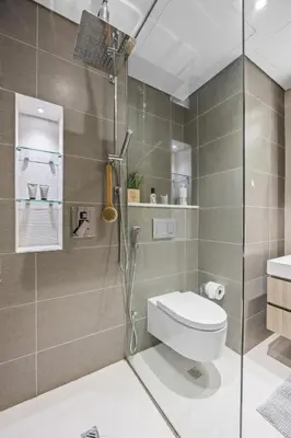 a bathroom with a shower with a toilet and a sink at Trendy Marina 2-Bedroom Apartment in Dubai